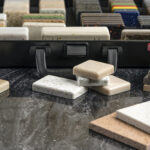 Large selection of stone samples for countertops and floors. Pieces of artificial acrylic stone in a sample box. A set of shades of countertops of different textures.